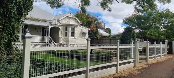 Decorative tubular fence in front of a heritage home